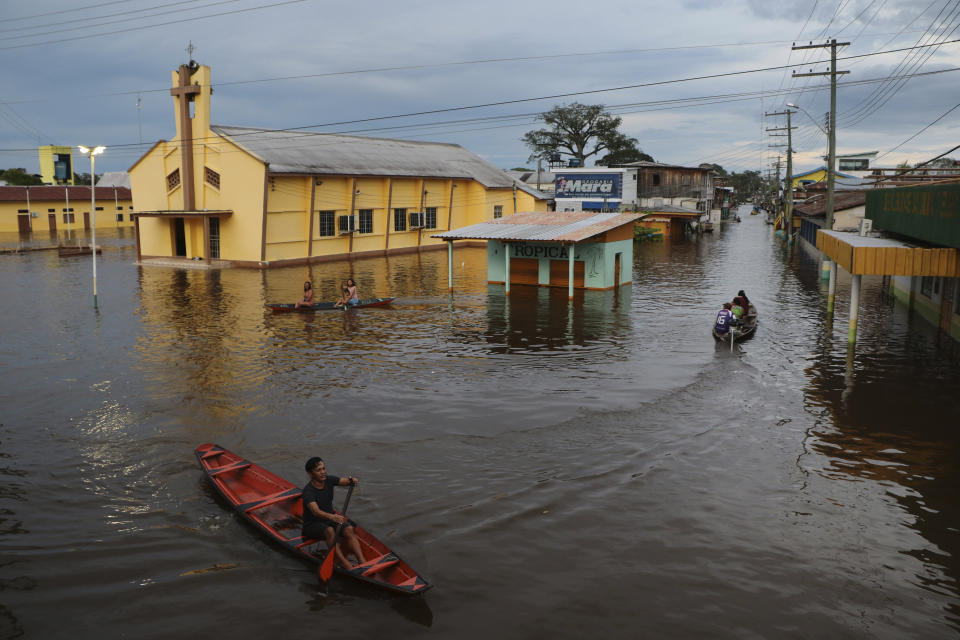 Residents navigate flooded streets in Anama, Amazonas state, Brazil, Thursday, May 13, 2021. (AP Photo/Edmar Barros)