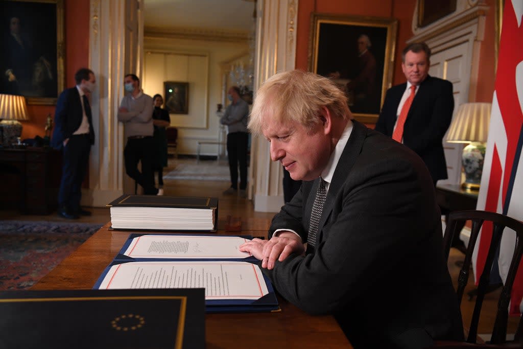 David Frost looks on as Prime Minister Boris Johnson prepares to sign the EU-UK Trade and Cooperation Agreement at 10 Downing Street, Westminster. (PA Archive)