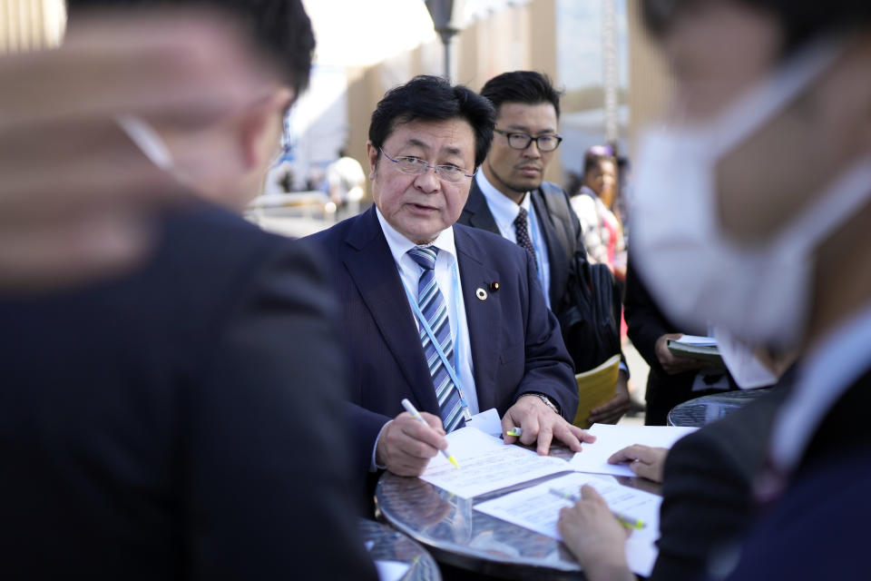 Akihiro Nishimura, minister of the environment of Japan, reviews notes with others at the COP27 U.N. Climate Summit, Friday, Nov. 18, 2022, in Sharm el-Sheikh, Egypt. (AP Photo/Peter Dejong)