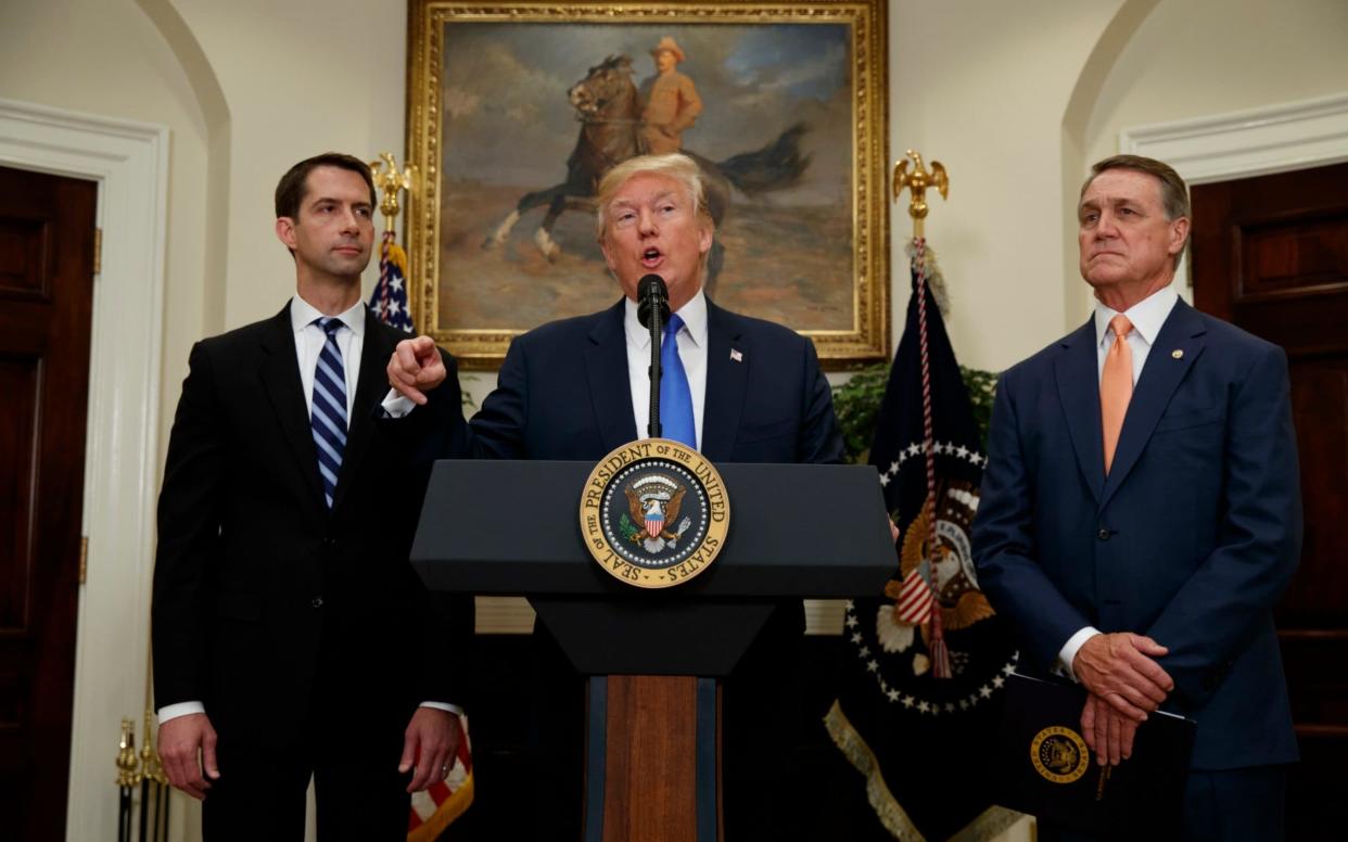 Donald Trump with David Perdue and Tom Cotton, inside the White House on Wednesday - AP