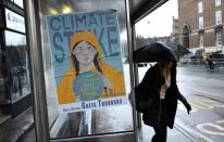 A woman walks next to a banner, ahead of a youth climate protest in Bristol