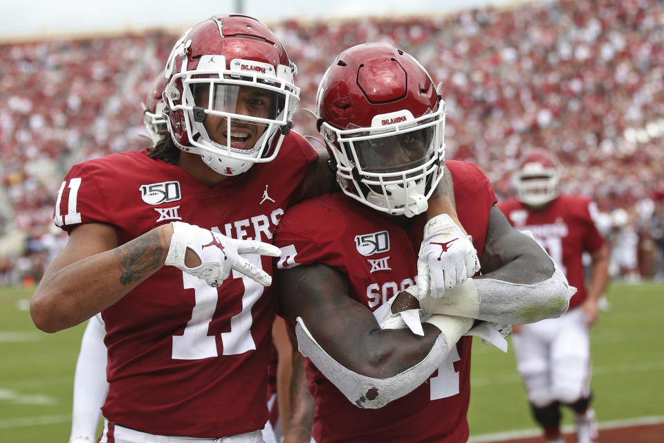 Oklahoma wide receiver Jadon Haselwood (11) and running back Trey Sermon (4) celebrate Sermon's touchdown in the third quarter of an NCAA college football game against Texas Tech in Norman, Okla., Saturday, Sept. 28, 2019. (AP Photo/Sue Ogrocki)