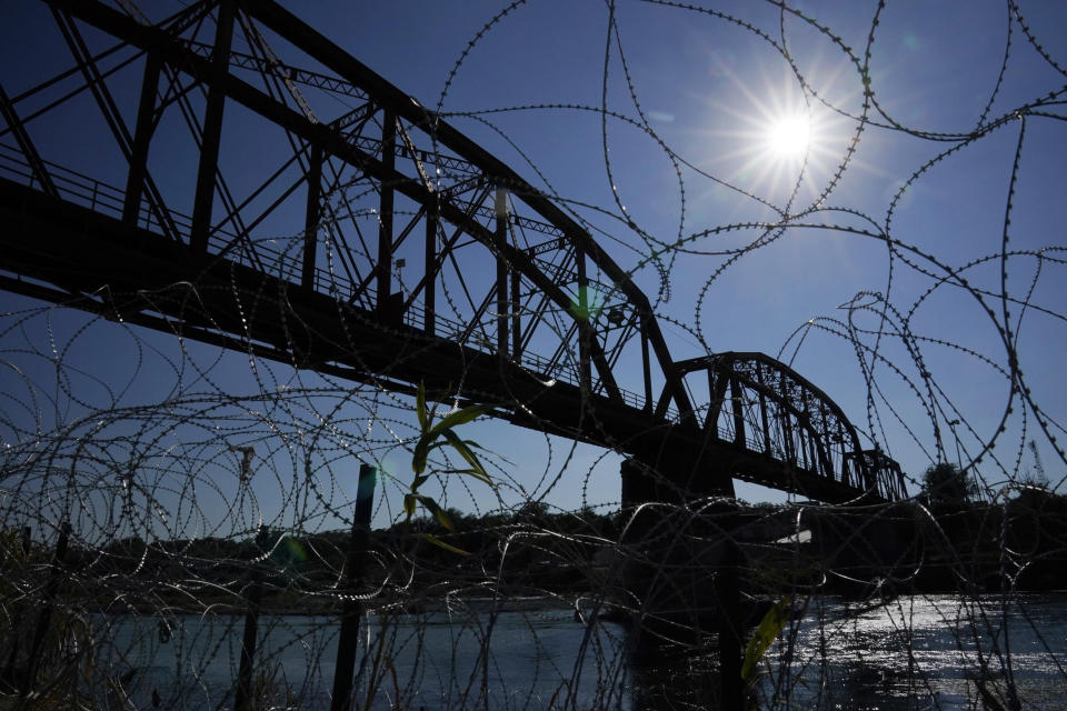 FILE - The Union Pacific International Railroad Bridge is seen behind concertina wire, Friday, Sept. 22, 2023, in Eagle Pass, Texas. The federal government has closed railroad crossings in two Texas border towns, including Eagle Pass, raising concerns about the potential impact on trade and goods available to American consumers. Carriers and politicians have decried the move that closes two of the six available railroad systems between Mexico and the U.S. (AP Photo/Eric Gay, File)