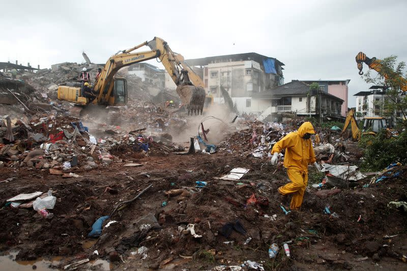 Rescue workers search for survivors in the debris after a five-story building collapsed in Mahad