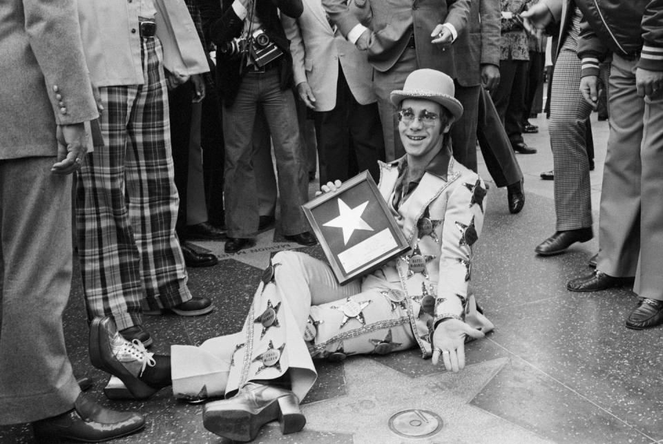1975: Elton John has his star and wears them, too