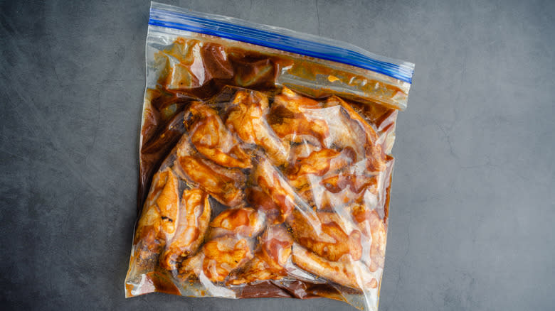 raw chicken marinating in plastic bag