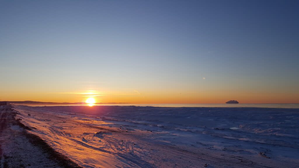 The sun sets, from the beach in Shaktoolik, Alaska, in 2019. (Alaska Division of Community and Regional Affairs photo)