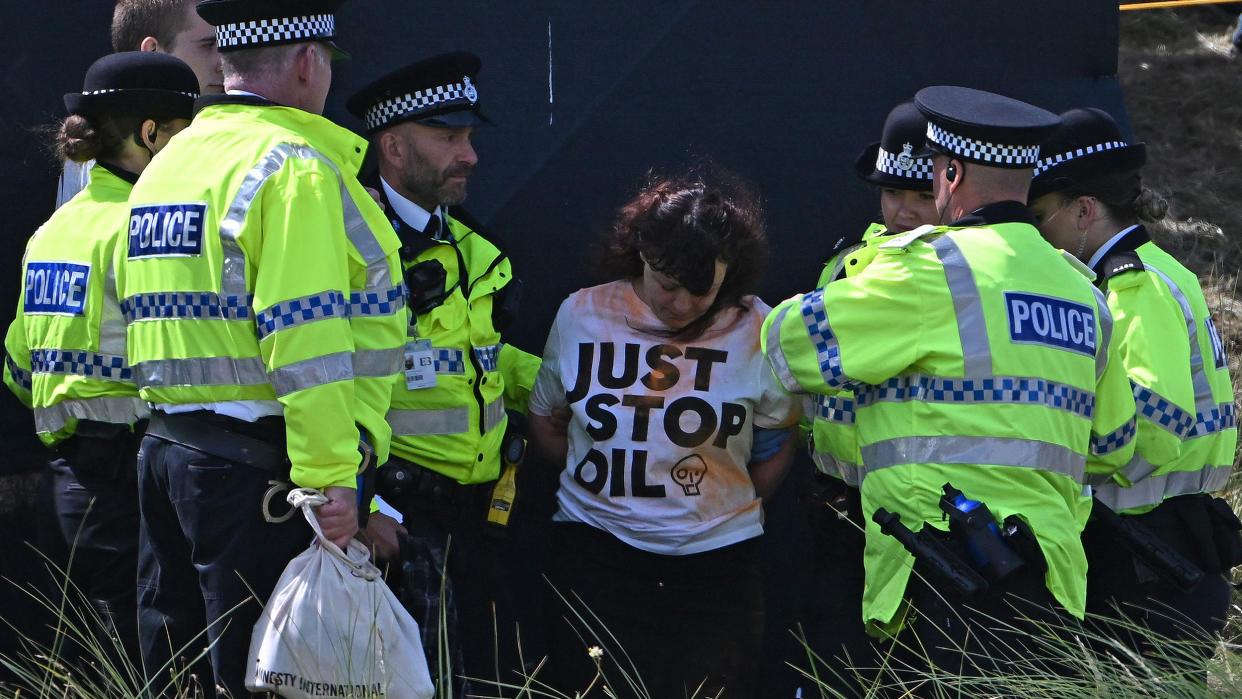  A woman wearing a 'Just Stop Oil' top being detained by police 