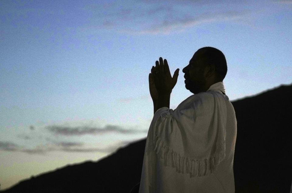 A Muslim pilgrim prays on top of the rocky hill known as the Mountain of Mercy, on the Plain of Arafat, during the annual hajj pilgrimage, near the holy city of Mecca, Saudi Arabia, Friday, July 8, 2022. (AP Photo/Amr Nabil)