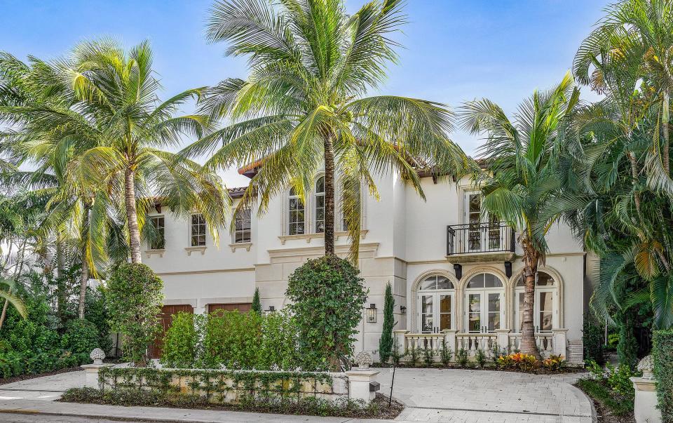 French doors with arched surrounds open to a patio with a balustrade on the front of the Mediterranean-style house at 230 Atlantic Ave.