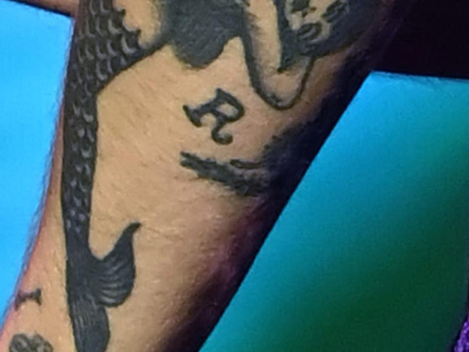 The letter "R" tattooed on Harry Styles' left arm.