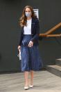 <p>Attending Wimbledon, the Duchess of Cambridge <a href="https://www.townandcountrymag.com/society/tradition/a36832463/kate-middleton-wimbledon-blue-skirt-outfit-2021-photos/" rel="nofollow noopener" target="_blank" data-ylk="slk:looked summery;elm:context_link;itc:0;sec:content-canvas" class="link ">looked summery</a> in a white top, navy blazer, and navy and white polka dot skirt. She accessorized with white shoes and a white purse and a patterned face mask.</p>