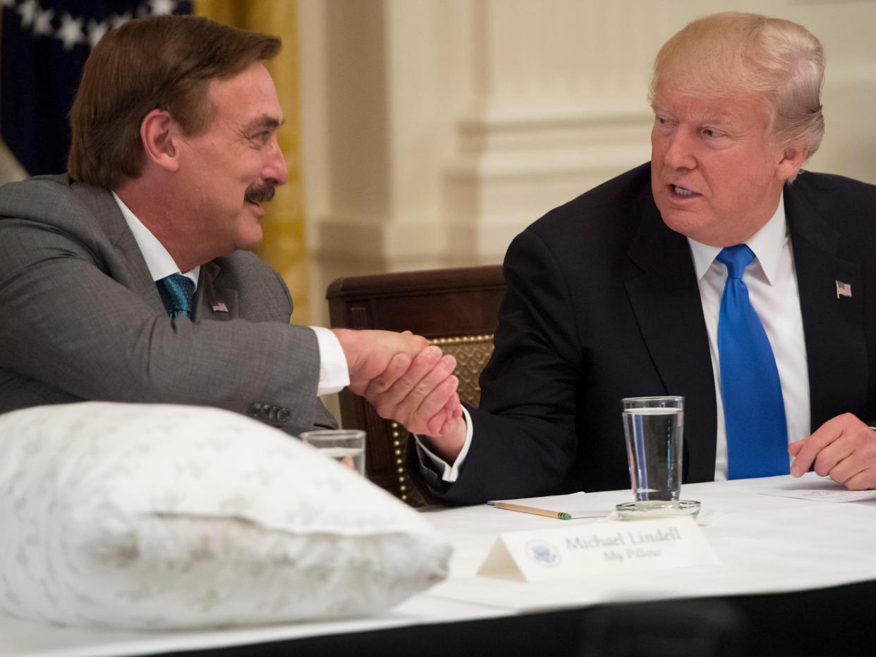 <p>President Trump shakes hands with Mike Lindell, founder of MyPillow, during a Made in America event with US manufacturers at the White House in July 2017</p> ((AFP via Getty Images))