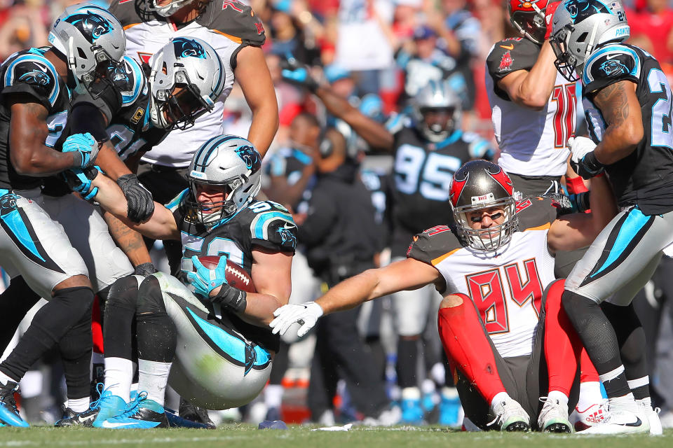 TAMPA, FL - OCTOBER 29: Luke Kuechly (59) of the Panthers is helped up after intercepting a Jameis Winston pass intended for Cameron Brate (84) of the Bucs during the regular season game between the Carolina Panthers and the Tampa Bay Buccaneers on October 29, 2017 at Raymond James Stadium in Tampa, Florida. (Photo by Cliff Welch/Icon Sportswire via Getty Images)