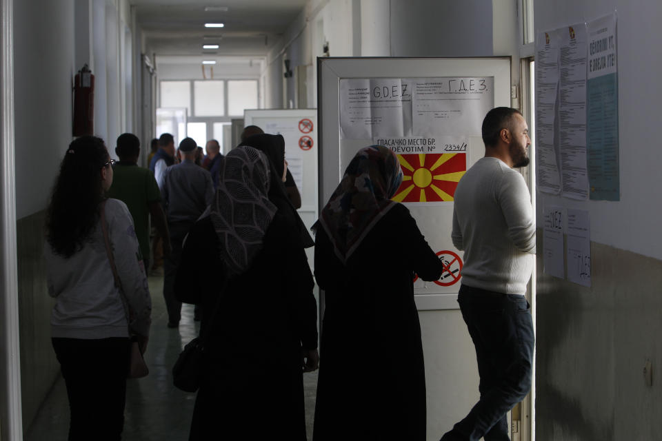 People wait in a queue to cast their ballots during a referendum in Skopje, Macedonia, Sunday, Sept. 30, 2018. Macedonians were deciding Sunday on their country's future, voting in a crucial referendum on whether to accept a landmark deal ending a decades-old dispute with neighbouring Greece by changing their country's name to North Macedonia, to qualify for NATO membership and also pave its way toward the European Union. (AP Photo/Thanassis Stavrakis)