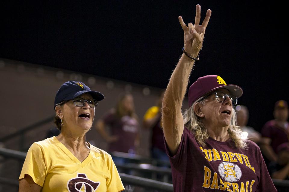 ASU fans Howard Varner and April Small sing 'Take Me Out to the Ball Game' during the seventh inning of a home game against UNLV held at Phoenix Municipal Stadium on Apr. 26, 2022.