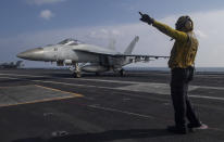 In this photo released by the U.S. Navy, Aviation Boatswain's Mate 3rd Class Marnell Maglasang, from La Puente, Calif., directs an F/A-18E Super Hornet on the flight deck of the aircraft carrier USS Nimitz in the Arabian Sea, Friday Nov. 27, 2020. The Nimitz returned to the Mideast in a move to support the drawdown of troops in Afghanistan and Iraq according to the Pentagon. However, the Nimitz's announced arrival came after the killing of an Iranian scientist who founded the Islamic Republic's military nuclear program in the early 2000s. (Mass Communication Specialist 3rd Class Cheyenne Geletka/U.S. Navy via AP)