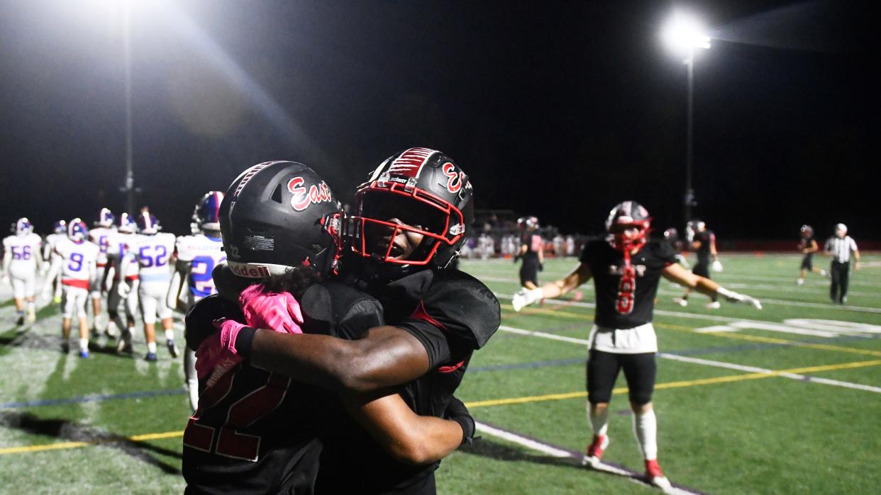 Cherry Hill East's Isaiah Donaldson, center, hugs teammate Denzel Lee, left, after Lee scored a touchdown during the football game between Cherry Hil East and Triton played at Cherry Hill East High School on Friday, September 13, 2024. Cherry Hill East defeated Triton, 31-7.