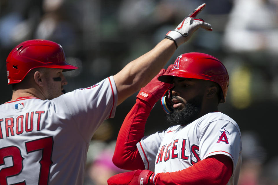 Los Angeles Angels' Luis Rengifo, right, is greeted by teammate Mike Trout as he scores on a double by Logan O'Hoppe against the Oakland Athletics during the third inning of a baseball game, Saturday, April 1, 2023, in Oakland, Calif. (AP Photo/D. Ross Cameron)