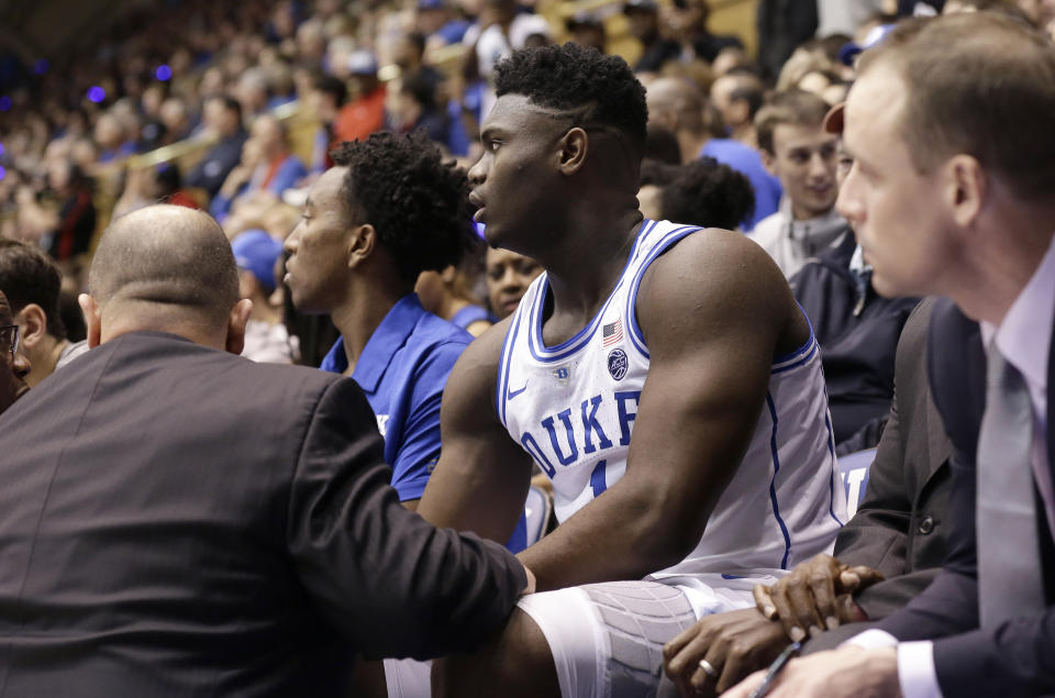 Duke's Zion Williamson (1) is attended to on the bench following an injury during the first half of an NCAA college basketball game against North Carolina in Durham, N.C., Wednesday, Feb. 20, 2019. (AP Photo/Gerry Broome)