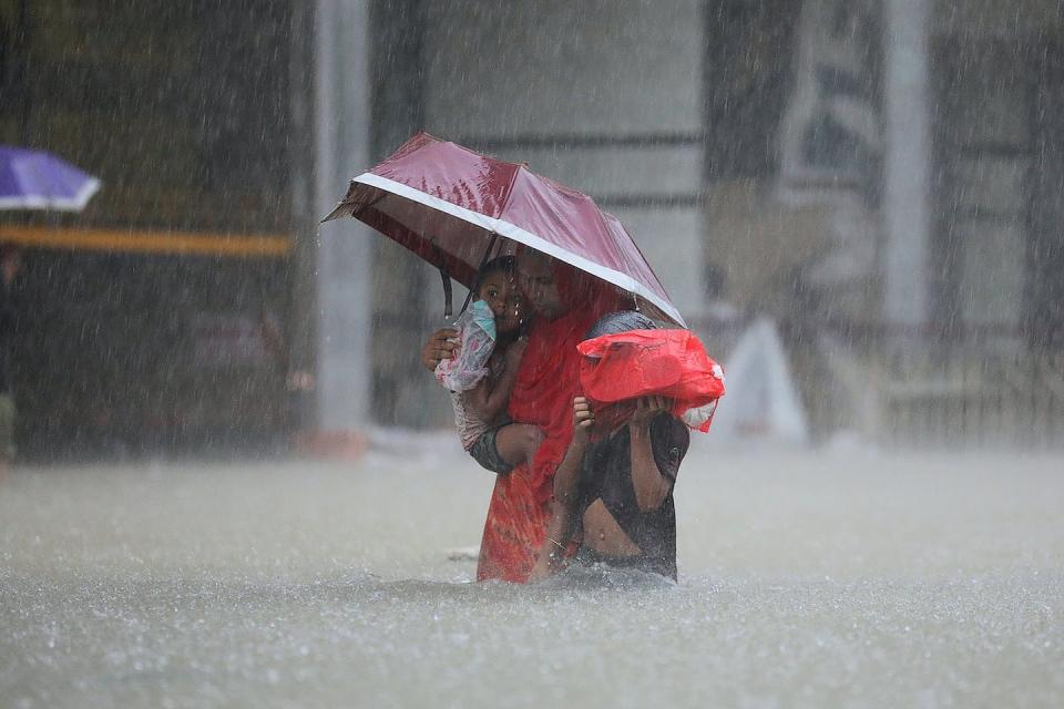 A warming climate can lead to more extreme downpours, as Bangladesh and India experienced in 2022. <a href="https://www.gettyimages.com/detail/news-photo/woman-with-children-wades-along-flooded-street-during-a-news-photo/1241384534" rel="nofollow noopener" target="_blank" data-ylk="slk:AFP via Getty Images;elm:context_link;itc:0;sec:content-canvas" class="link ">AFP via Getty Images</a>