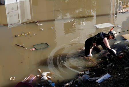 A rescue worker checks around a flooded residential area due to Typhoon Hagibis, in Kawasaki, Japan