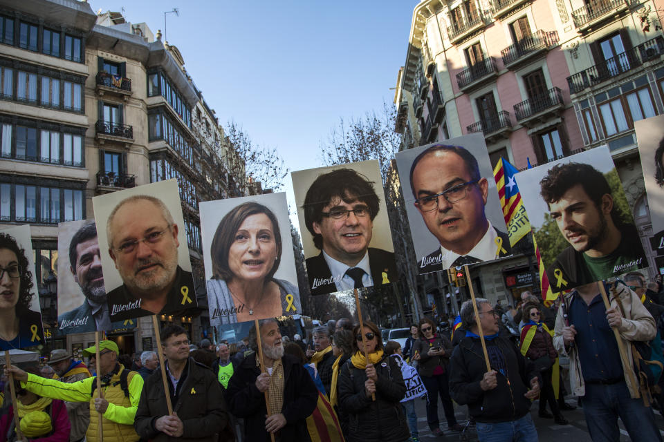 FILE - In this Saturday, Feb. 16, 2019 file photo, pro independence demonstrators hold photos of imprisoned and exiled pro-independence political leaders, during a demonstration in Barcelona, Spain. A dozen politicians and activists on trial for their failed bid in 2017 to carve out an independent Catalan republic in northeastern Spain will deliver their final statements Wednesday June 12, 2019, as four months of hearings draw to an end. (AP Photo/Emilio Morenatti, File)