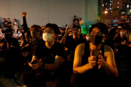 Anti-extradition bill protesters react as they watch a documentary protest video during a protest outside Siu Hong station in Hong Kong