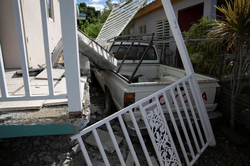 A car is seen under debris of a collapsed house after an earthquake in Guanica