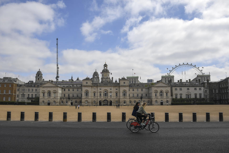 Two women ride bicycles past the Horse Guards Parade, during lockdown due to the coronavirus outbreak, in London, Saturday, April 25, 2020.(AP Photo/Alberto Pezzali)