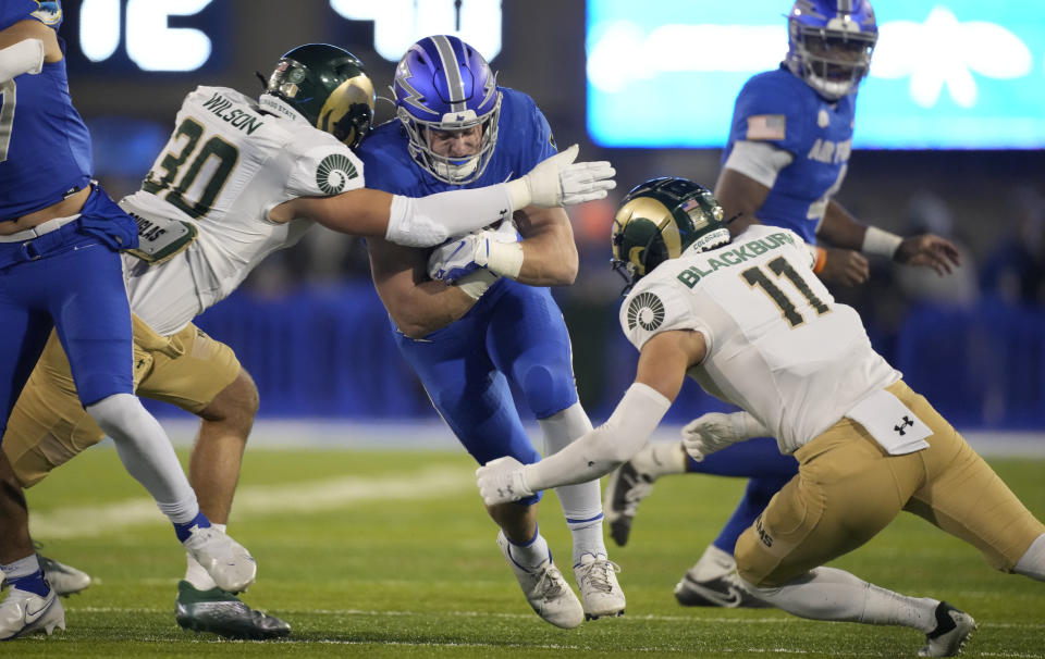 Air Force running back Brad Roberts, center, is stopped after a short gain by Colorado State linebacker Chase Wilson, left, and defensive back Henry Blackburn in the first half of an NCAA college football game Saturday, Nov. 19, 2022, at Air Force Academy, Colo. (AP Photo/David Zalubowski)