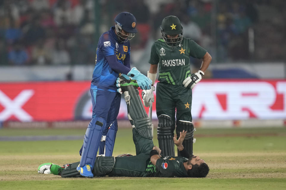 Sri Lanka's Sadeera Samarawickrama, right, helps Pakistan's Mohammad Rizwan to ease a leg muscle cramp during the ICC Men's Cricket World Cup match between Pakistan and Sri Lanka in Hyderabad, India, Tuesday, Oct. 10, 2023. (AP Photo/Rafiq Maqbool)