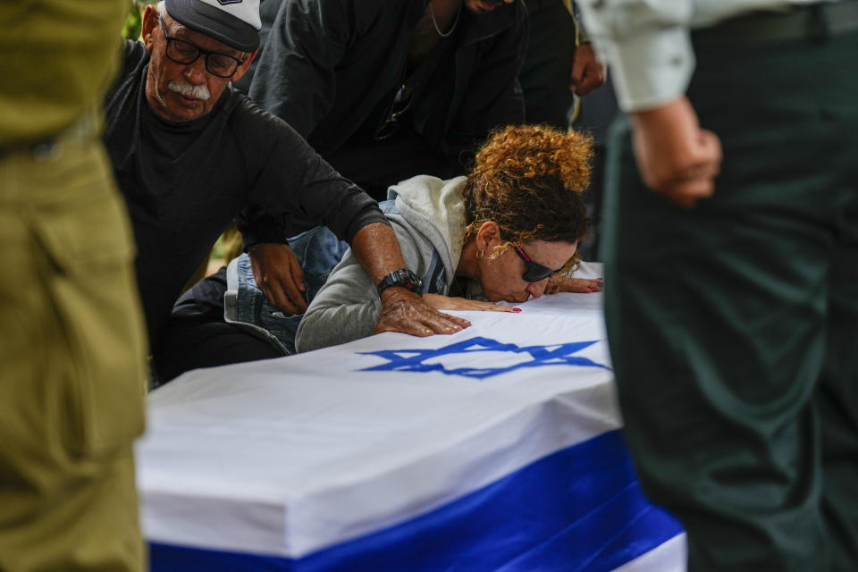 Ami Aviv mother of Israeli reserve soldier Master sergeant Ido Aviv kisses his casket during his the funeral in Carmiel, northern Israel, Tuesday, April 30, 2024. Aviv, 28, was killed during Israel's ground operation in the Gaza Strip, where the Israeli army has been battling Palestinian militants in the war ignited by Hamas' Oct. 7 attack into Israel. (AP Photo/Ariel Schalit)