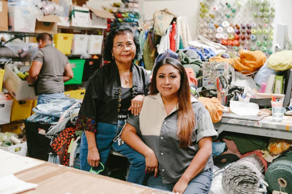 Two people smile in a textile business.