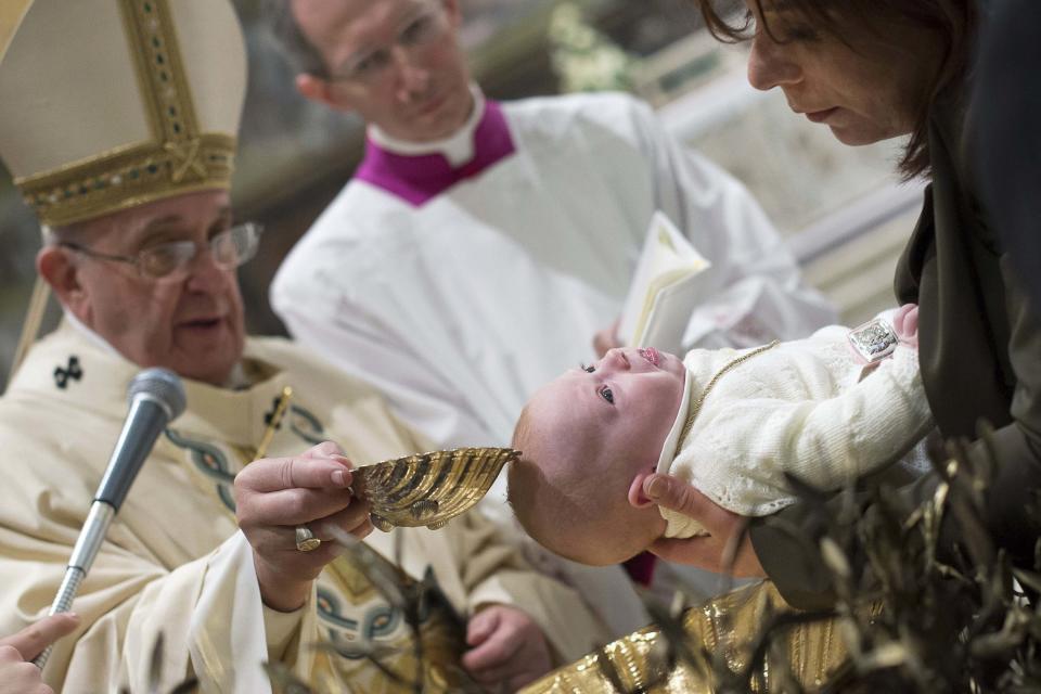 Pope Francis baptises a newborn during a solemn mass in the Sistine Chapel at the Vatican January 11, 2015. Pope Francis baptized 33 infants in the Sistine Chapel on Sunday and told the mothers to feel free to breastfeed them if they cried or were hungry. REUTERS/Osservatore Romano (VATICAN - Tags: SOCIETY RELIGION TPX IMAGES OF THE DAY) ATTENTION EDITORS - THIS PICTURE WAS PROVIDED BY A THIRD PARTY. REUTERS IS UNABLE TO INDEPENDENTLY VERIFY THE AUTHENTICITY, CONTENT, LOCATION OR DATE OF THIS IMAGE. NO SALES. NO ARCHIVES. FOR EDITORIAL USE ONLY. NOT FOR SALE FOR MARKETING OR ADVERTISING CAMPAIGNS. THIS PICTURE IS DISTRIBUTED EXACTLY AS RECEIVED BY REUTERS, AS A SERVICE TO CLIENTS
