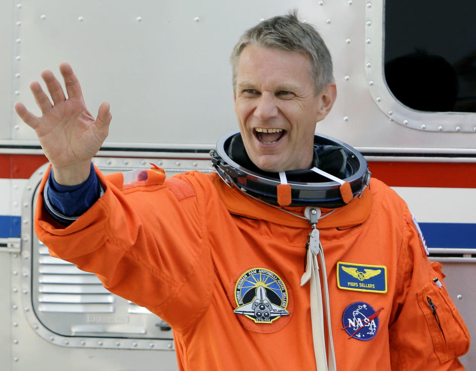 FILE- Int his May 10, 2010, file photo, STS-132 British-born, U.S. astronaut Piers Sellers waves to the media as he leaves the Operations and Checkout Building with fellow crew members for a trip to launch pad 39-A and a planned liftoff on the space shuttle Atlantis at the Kennedy Space Center in Cape Canaveral, Fla. Sellers, a climate scientist and former astronaut died Friday, Dec. 23, 2016. He was 61. (AP Photo/Chris O'Meara, File)