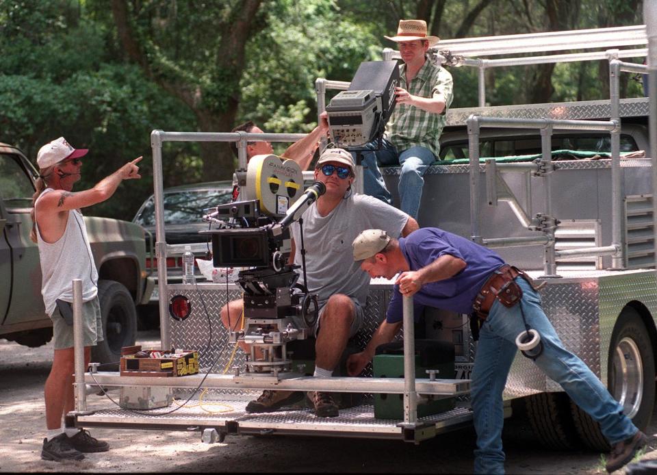 "The General's Daughter" director Simon West (top, wearing straw hat)  looks through a monitor while sitting on the camera truck. Camera operator Robert Presley (center) prepares to film convoy scene at Wormsloe. West also directed "Con Air.'' Bob Morris photo.