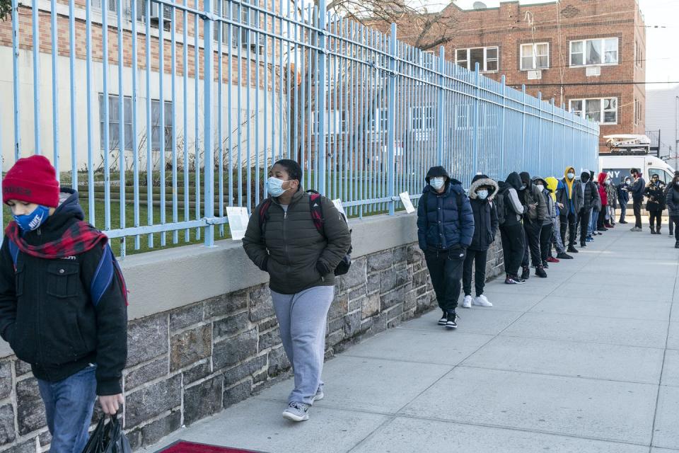 Grade school students line up to walk to school.