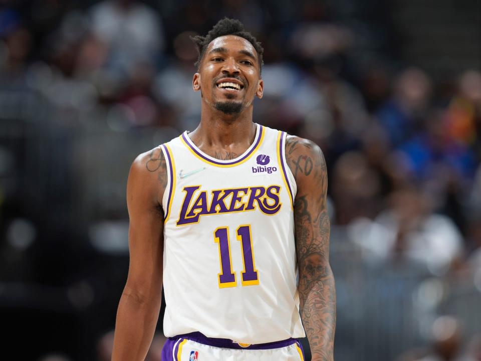 Malik Monk smiles while walking on the court during a game.