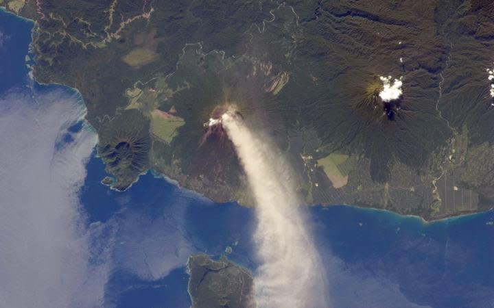 被稱為全球最危險火山之一的巴布亞紐幾內亞烏拉旺火山(Ulawun volcano)，26日開始噴發火山灰，把天空染成黑色，導致居民紛紛逃離並觸發噴發警示。(圖：NASA)