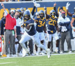 West Virginia running back Leddie Brown (4) rushes the ball against TCU during the second half of an NCAA college football game on Saturday, Nov. 14, 2020, in Morgantown, W.Va. (William Wotring/The Dominion-Post via AP)