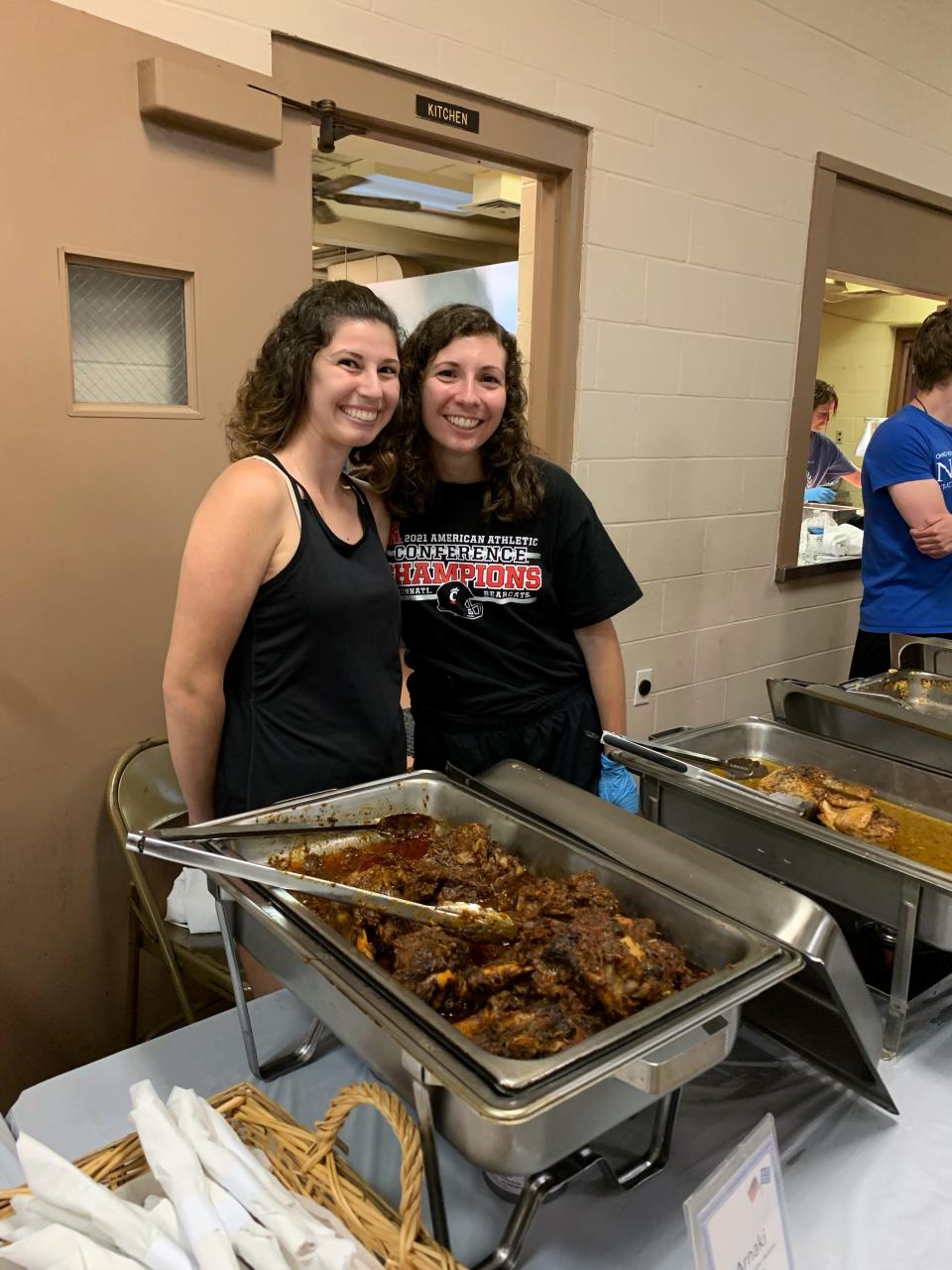 Two church volunteers help serve Greek food at the festival.