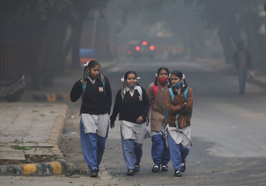 Schoolgirls walk towards a school as they reopened after remaining closed for nearly 15 days due to a spike in air pollution, on a smoggy morning in New Delhi (REUTERS)