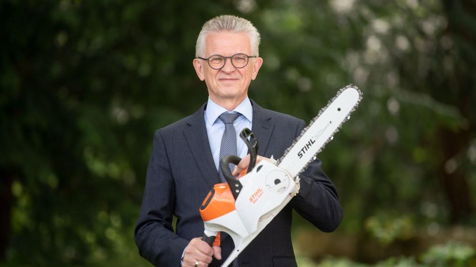 Bertram Kandziora, Vorstandsvorsitzender der Stihl AG, posiert mit einer akkubetriebenen Motorsäge.