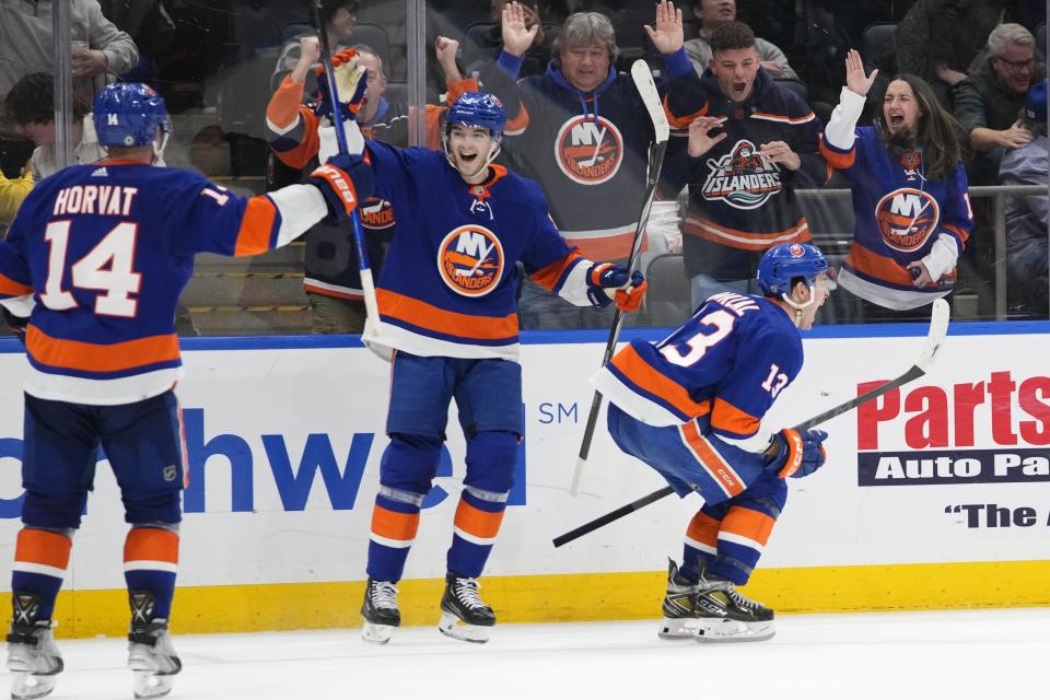 New York Islanders' Mathew Barzal (13) celebrates with teammates Noah Dobson (8) and Bo Horvat (14) after scoring the winning goal during the overtime period of an NHL hockey game against the Toronto Maple Leafs, Thursday, Jan. 11, 2024, in Elmont, N.Y. (AP Photo/Frank Franklin II)