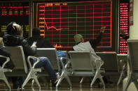 In this Thursday, Dec. 12, 2019, photo, investors monitor stock prices at a brokerage in Beijing. Shares likewise jumped Friday, Dec. 13, 2019 in Asia following fresh all-time highs overnight on Wall Street spurred by optimism that the U.S. and China are close to reaching a deal to end their costly trade war. (AP Photo/Ng Han Guan)