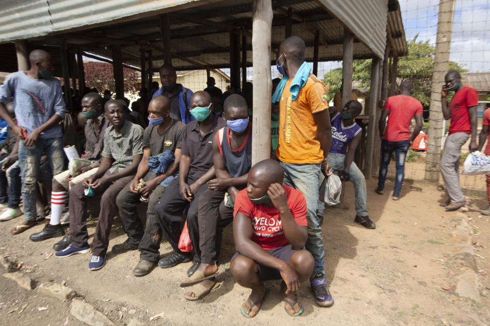 Prisoners wait for transport following their release from Chikurubi prison on the outskirts of Harare, Saturday, April 17, 2021. Zimbabwe began the release of about 3,000 prisoners under a presidential amnesty aimed at easing congestion and minimizing the threat of COVID-19 across the country's overcrowded jails. (AP Photo/Tsvangirayi Mukwazhi)