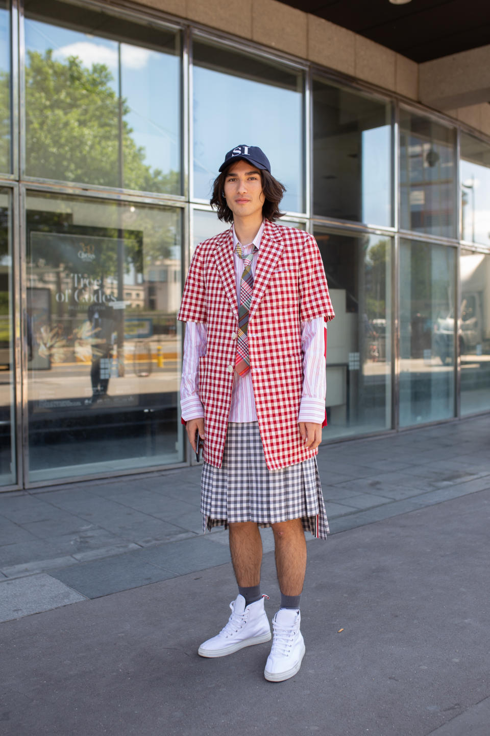 PARIS, FRANCE - JUNE 22: Blake Abbie is seen on the street during men's Paris Fashion Week wearing red checker blazer with green checker skirt and neck tie with navy cap and white sneakers on June 22, 2019 in Paris, France. (Photo by Matthew Sperzel/Getty Images)