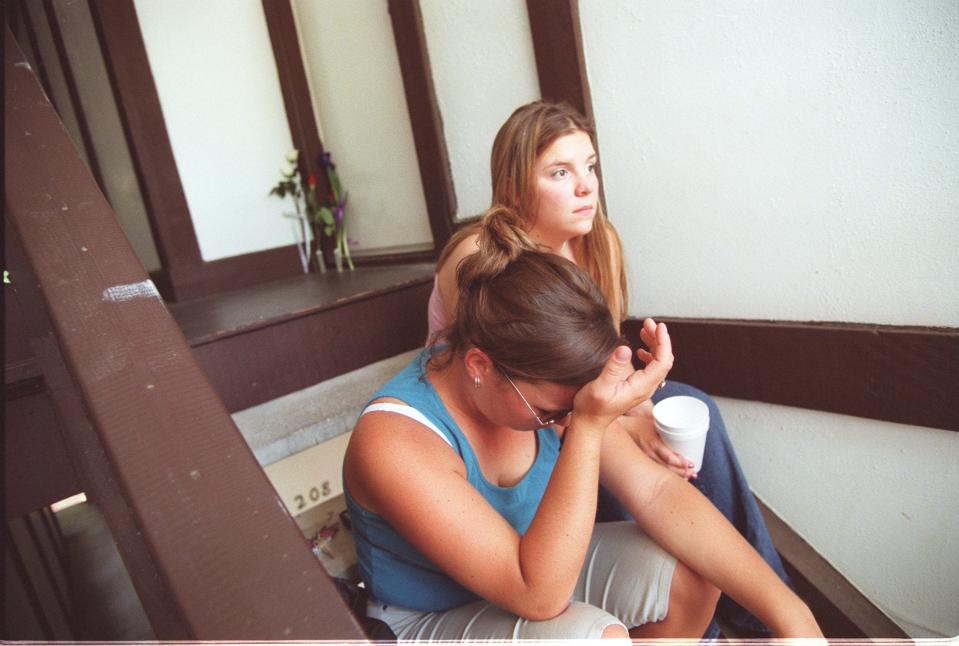Lauren Robinson grieves on the stairs to Kelsea Helton and Eric Carpenter's apartment at Lake in the Pines after placing flowers at their door Aug. 9, 2001. Helton and Carpenter were killed Aug. 7, 2001.