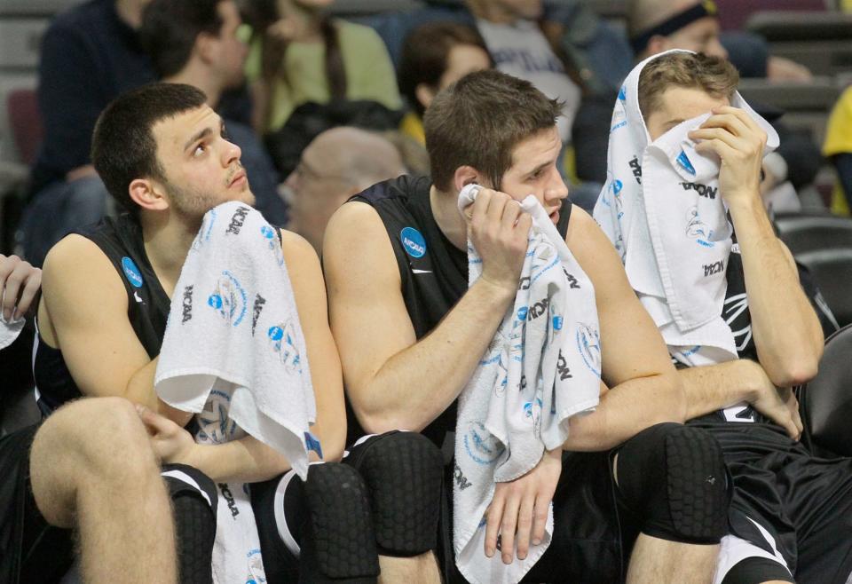 Akron's Carmelo Betancourt (from left), Jake Kretzer and Brian Walsh sit on the bench dejected as they watch VCU roll to a 88-42 win in an NCAA tournament.